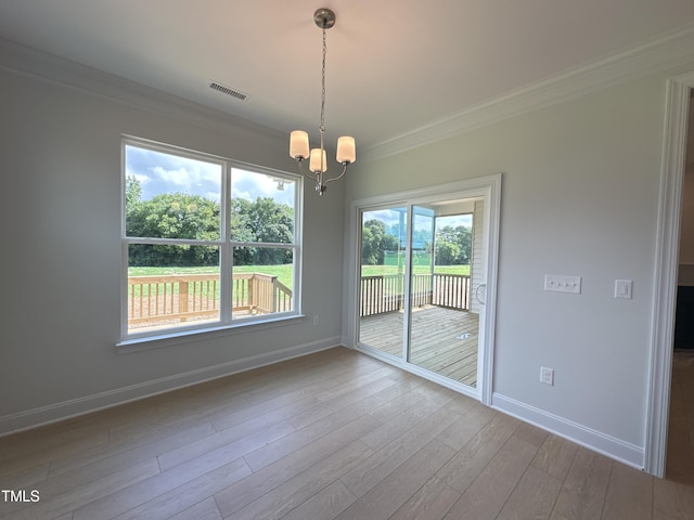 unfurnished dining area with an inviting chandelier, crown molding, and hardwood / wood-style flooring