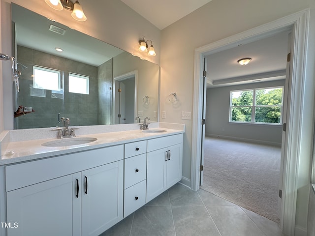 bathroom featuring vanity, tile patterned flooring, and a shower