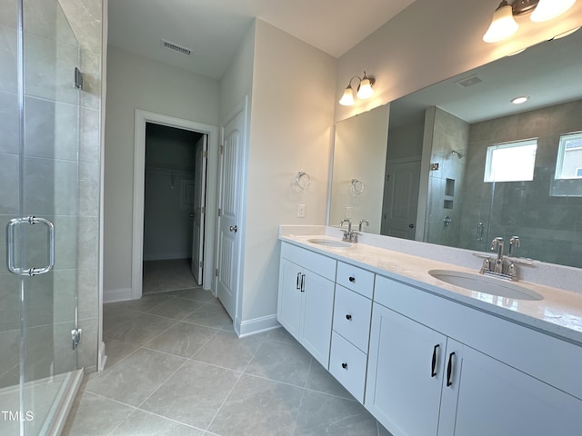 bathroom featuring tile patterned flooring, a shower with door, and vanity