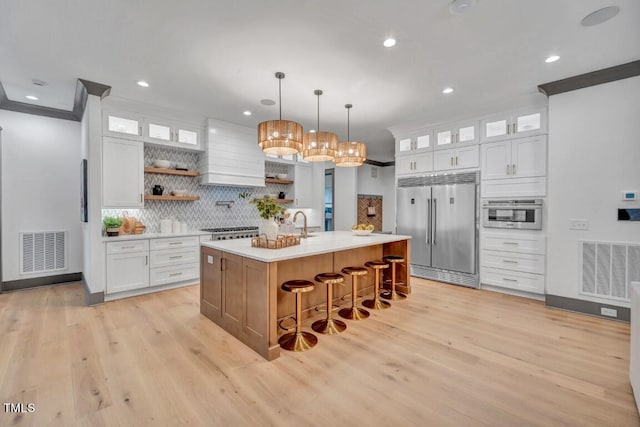 1312 Hunting Ridge Rd, Raleigh, NC 27615 - kitchen featuring stainless steel appliances, open shelves, tasteful backsplash, light countertops, and light wood-type flooring