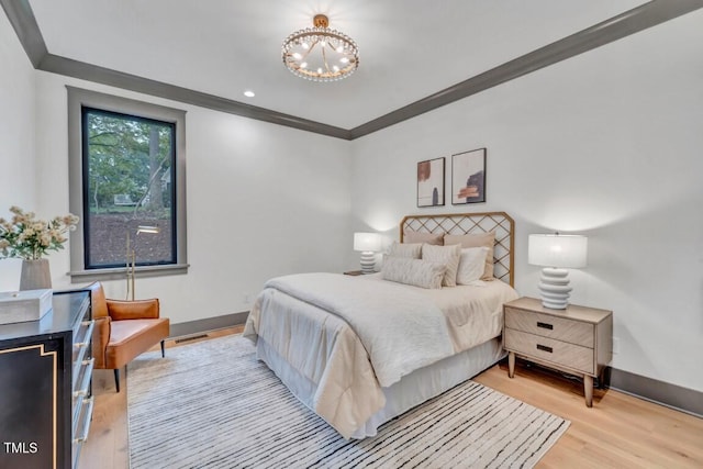 bedroom with light wood-type flooring, crown molding, and an inviting chandelier