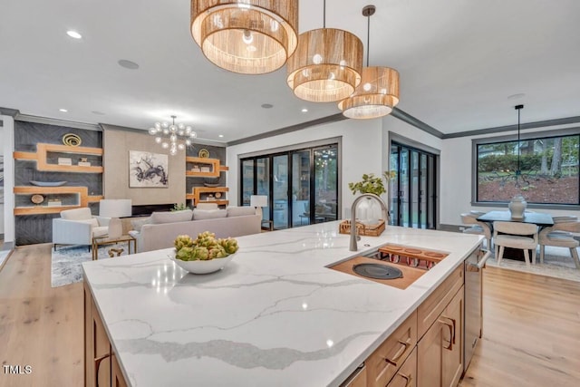 1312 Hunting Ridge Rd, Raleigh, NC 27615 - kitchen with a sink, light wood-style floors, a chandelier, crown molding, and hanging light fixtures