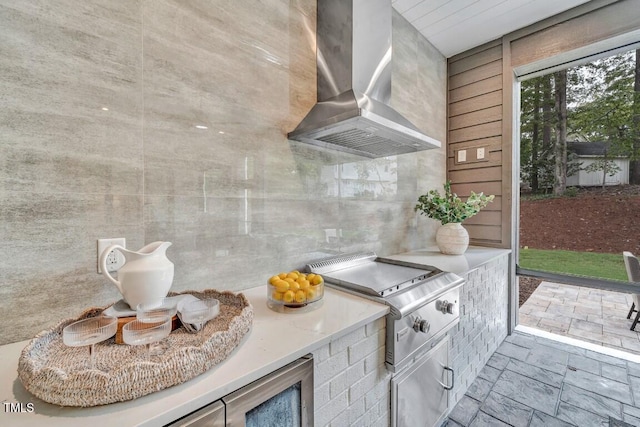 kitchen featuring tile walls and wall chimney range hood