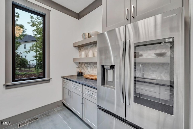 1312 Hunting Ridge Rd, Raleigh, NC 27615 - kitchen with stainless steel refrigerator with ice dispenser, open shelves, decorative backsplash, and dark stone counters