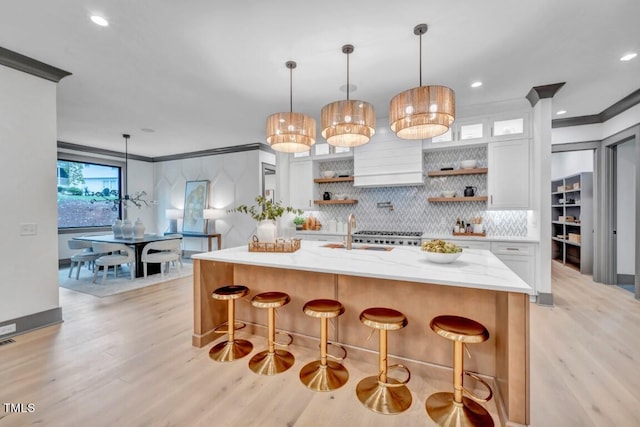 1312 Hunting Ridge Rd, Raleigh, NC 27615 - kitchen with open shelves, light wood-type flooring, tasteful backsplash, a sink, and ornamental molding