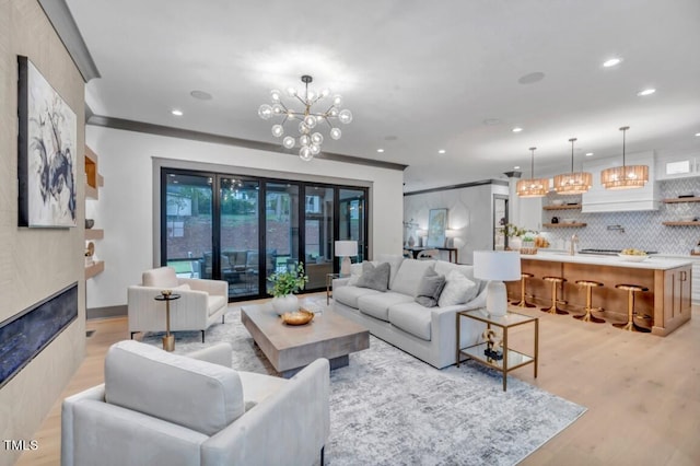 1312 Hunting Ridge Rd, Raleigh, NC 27615 - living room with a chandelier, light wood-type flooring, recessed lighting, and a glass covered fireplace