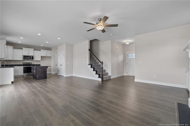 unfurnished living room featuring dark hardwood / wood-style floors, sink, and ceiling fan