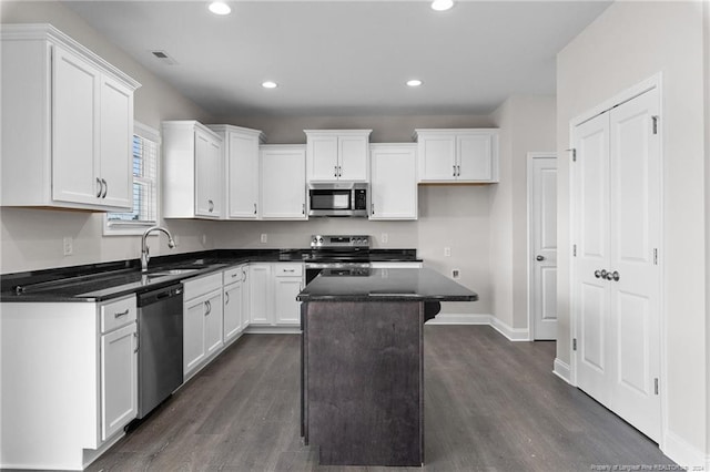 kitchen featuring white cabinetry, sink, a kitchen island, and appliances with stainless steel finishes