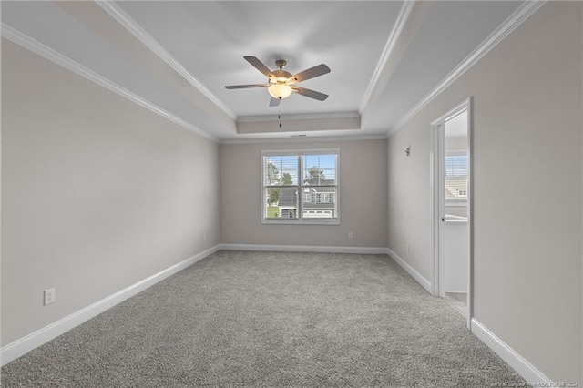 carpeted empty room featuring ceiling fan, ornamental molding, and a raised ceiling