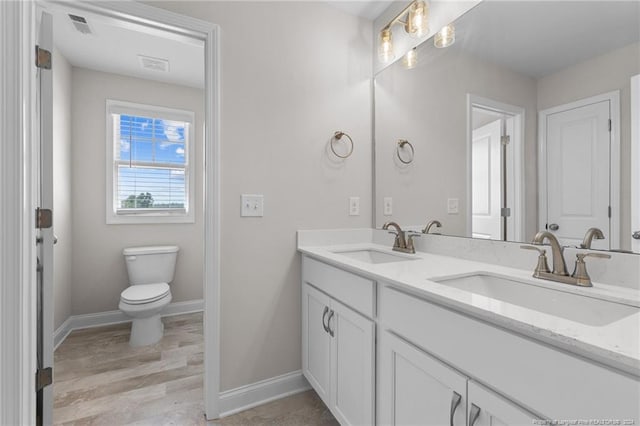 bathroom featuring vanity, wood-type flooring, and toilet