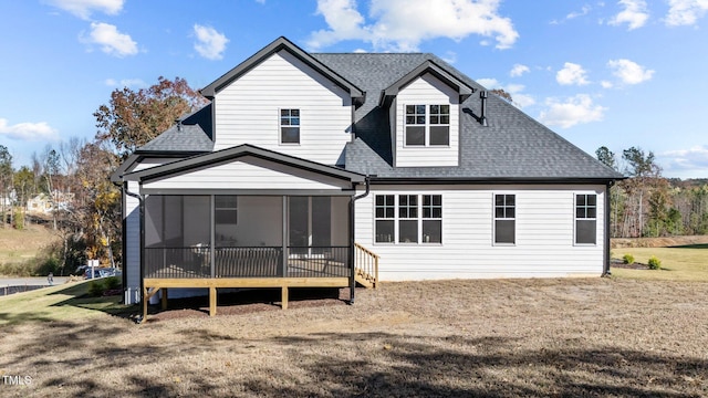rear view of house featuring a yard and a sunroom
