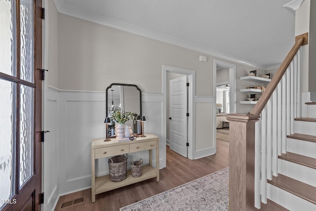 entryway with ornamental molding and light hardwood / wood-style floors