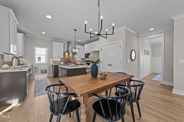 dining space featuring crown molding and light wood-type flooring
