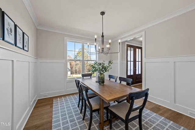 dining room with a notable chandelier, dark wood-type flooring, and ornamental molding