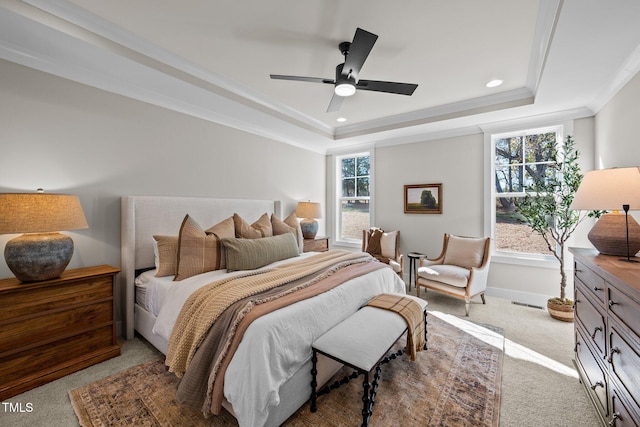carpeted bedroom featuring crown molding, ceiling fan, and a raised ceiling