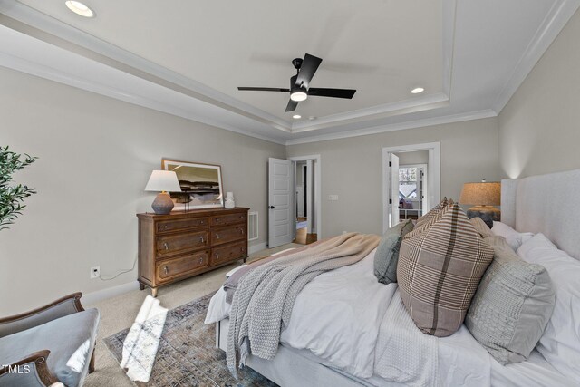 carpeted bedroom featuring ornamental molding, a raised ceiling, and ceiling fan