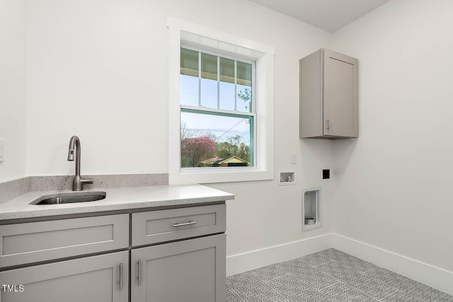 clothes washing area with light tile floors, sink, hookup for a washing machine, electric dryer hookup, and cabinets