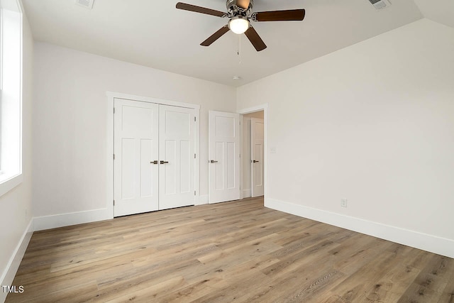 unfurnished bedroom featuring ceiling fan, vaulted ceiling, and light wood-type flooring