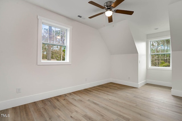 bonus room with ceiling fan, a wealth of natural light, and light hardwood / wood-style flooring