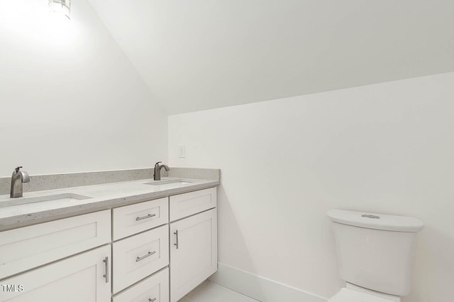 bathroom with lofted ceiling, toilet, double vanity, and tile floors