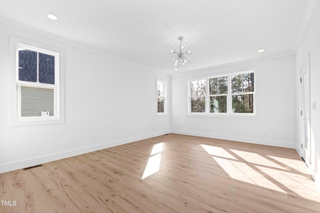 empty room with a notable chandelier, light hardwood / wood-style floors, and crown molding