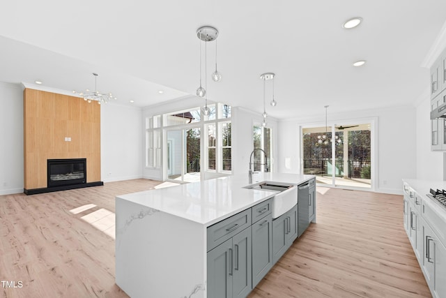 kitchen with a fireplace, decorative light fixtures, gray cabinets, and sink