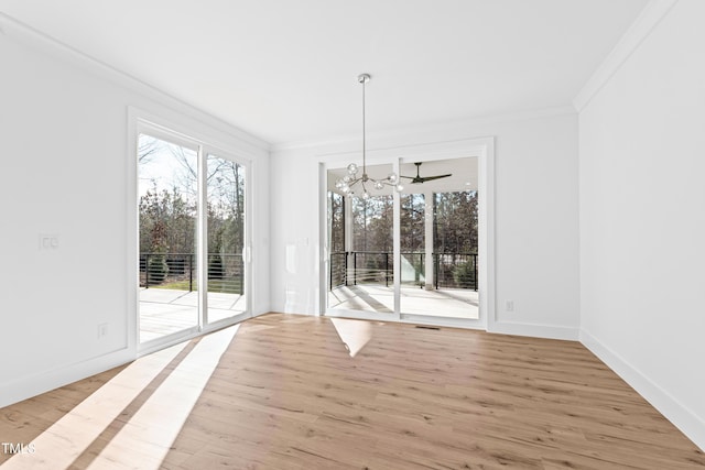 unfurnished dining area with a notable chandelier, crown molding, and light hardwood / wood-style flooring