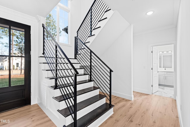 stairs featuring crown molding and hardwood / wood-style floors