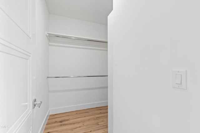 walk in closet with light wood-type flooring