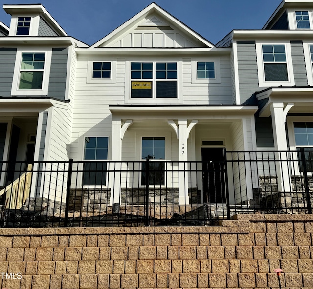 townhome / multi-family property with covered porch and board and batten siding