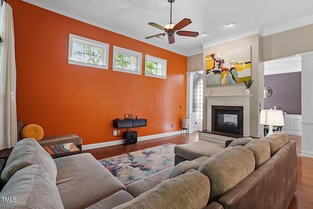 living room with a high end fireplace, hardwood / wood-style floors, ceiling fan, and ornamental molding