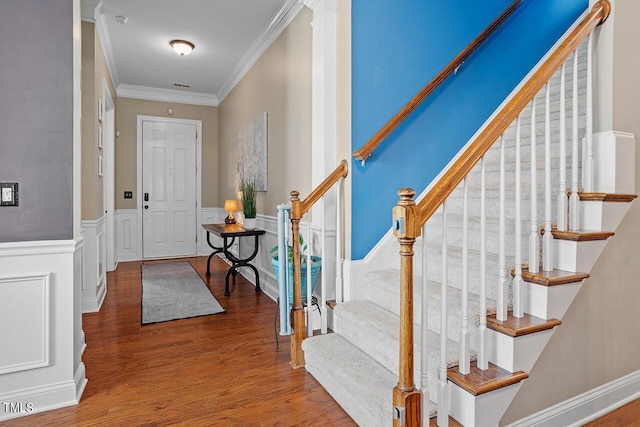 entrance foyer with wood-type flooring and ornamental molding