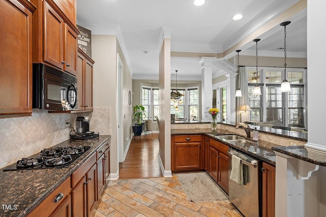 kitchen with black appliances, sink, dark stone countertops, light wood-type flooring, and ornamental molding