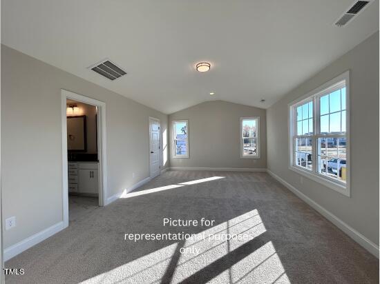 carpeted empty room with lofted ceiling