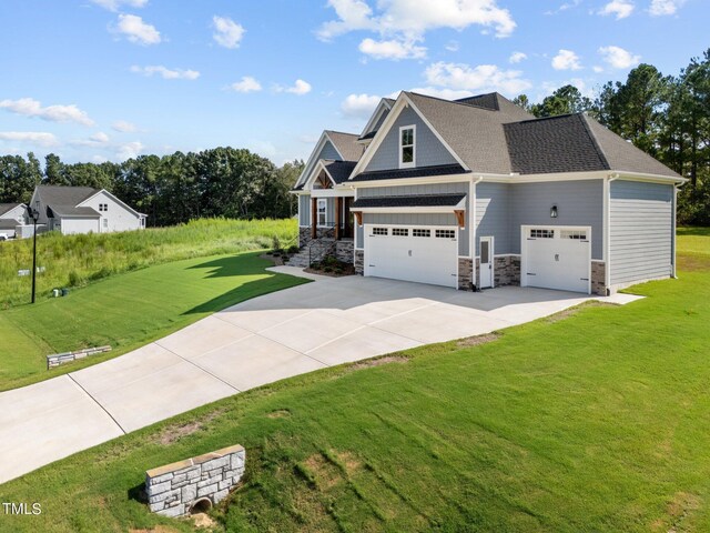 craftsman inspired home featuring a garage and a front lawn