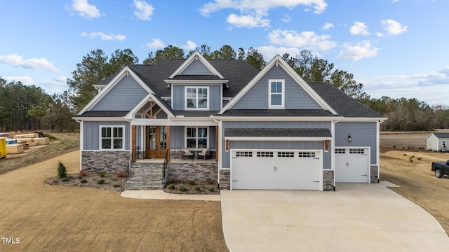 craftsman inspired home with stone siding, concrete driveway, and a garage