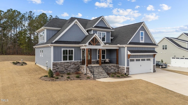 craftsman-style house with concrete driveway, stone siding, an attached garage, a porch, and board and batten siding