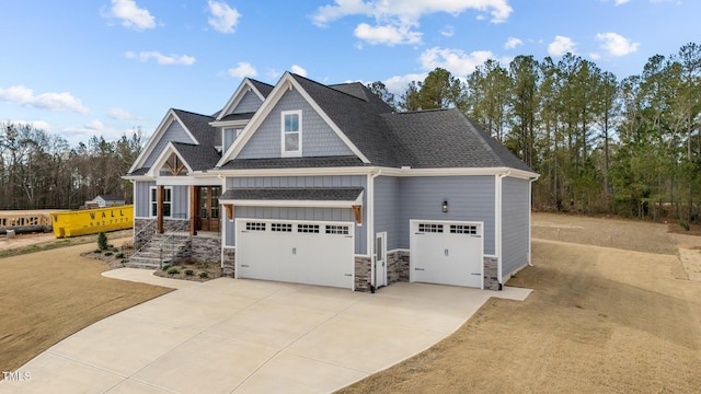 262 Hook Dr Lot 12, Fuquay Varina, NC 27526 - view of front of house featuring stone siding, board and batten siding, driveway, roof with shingles, and an attached garage
