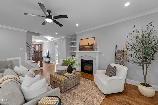 262 Hook Dr Lot 12, Fuquay Varina, NC 27526 - living area with stairs, a ceiling fan, arched walkways, wood finished floors, and crown molding