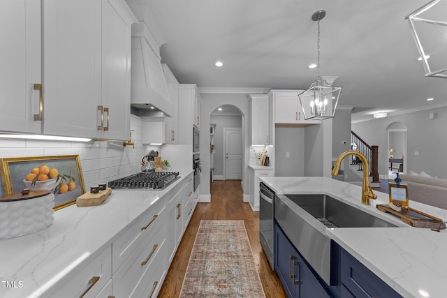 262 Hook Dr Lot 12, Fuquay Varina, NC 27526 - kitchen featuring blue cabinets, arched walkways, white cabinetry, stainless steel appliances, and a sink