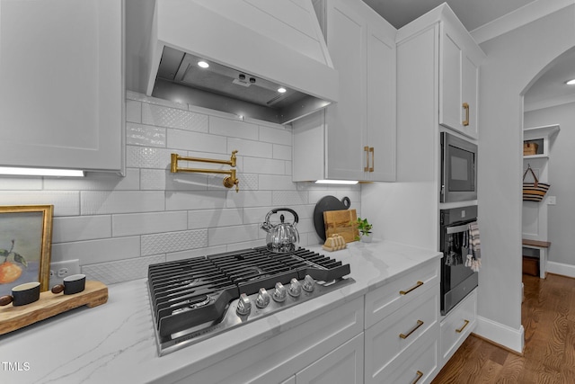 262 Hook Dr Lot 12, Fuquay Varina, NC 27526 - kitchen featuring oven, stainless steel gas stovetop, premium range hood, arched walkways, and built in microwave