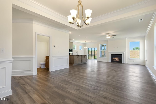 unfurnished living room featuring crown molding, dark wood-type flooring, and a healthy amount of sunlight