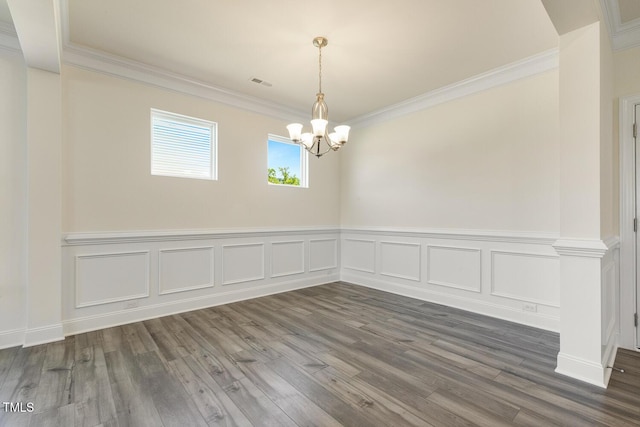 unfurnished room with dark hardwood / wood-style floors, crown molding, and an inviting chandelier