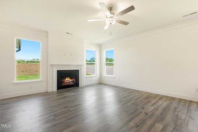 unfurnished living room featuring dark hardwood / wood-style floors, crown molding, and a healthy amount of sunlight