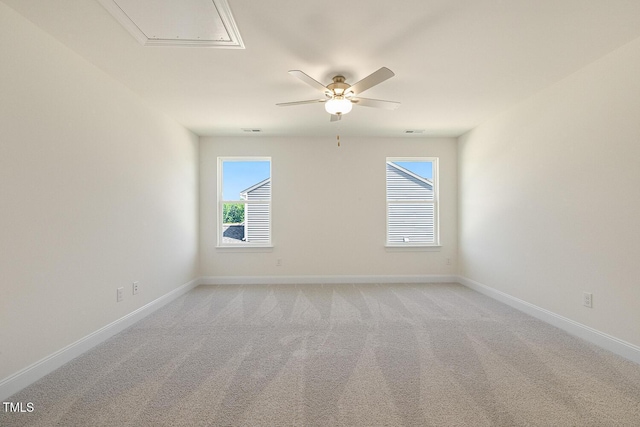 spare room featuring a wealth of natural light, ceiling fan, and light colored carpet