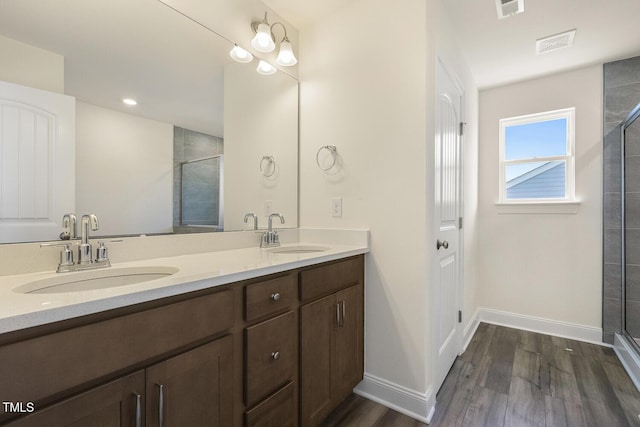 bathroom featuring hardwood / wood-style floors, vanity, and walk in shower