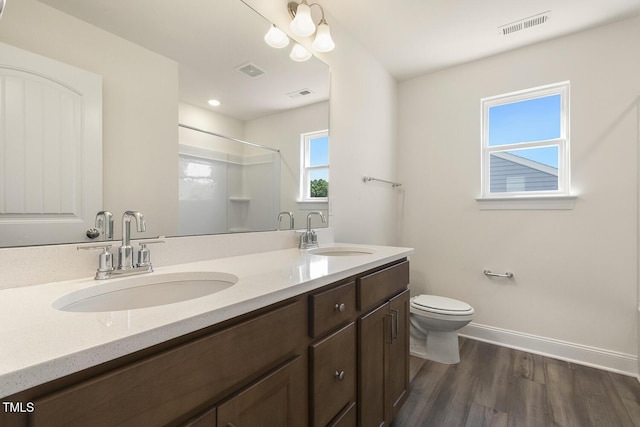 bathroom with walk in shower, toilet, vanity, and hardwood / wood-style flooring