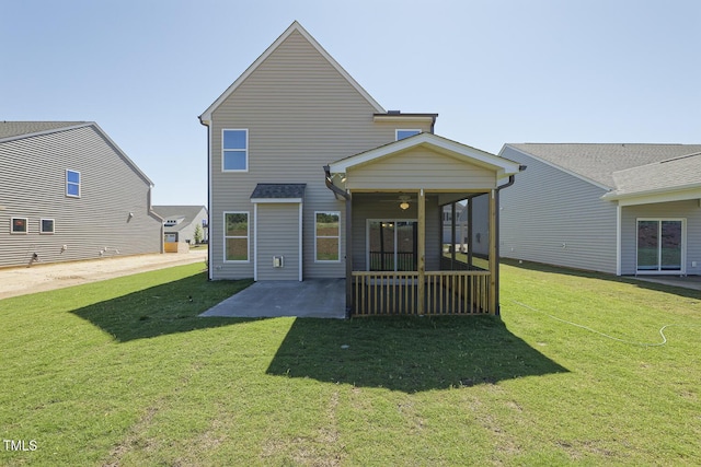 rear view of house featuring a sunroom, a yard, and a patio