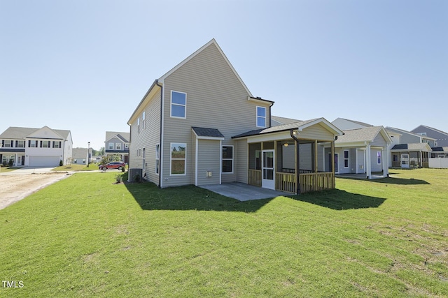 rear view of property with a yard and a sunroom