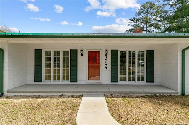 5027 Lake Willett Rd, Sanford, NC 27332 - property entrance featuring a chimney, concrete block siding, a porch, and metal roof